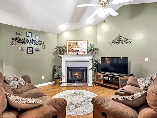 204 Bluff Ct, Jackson, GA 30233 - living area with a ceiling fan, wood finished floors, a tiled fireplace, baseboards, and lofted ceiling
