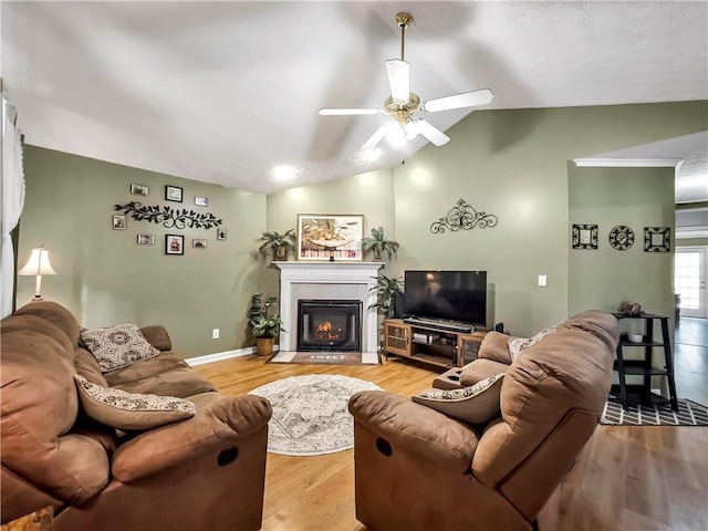 204 Bluff Ct, Jackson, GA 30233 - living area with ceiling fan, vaulted ceiling, light wood finished floors, a warm lit fireplace, and baseboards
