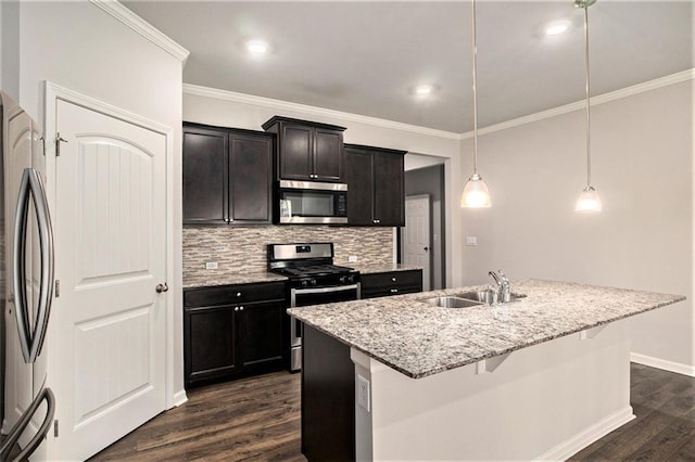 kitchen with light stone countertops, dark wood-style flooring, a sink, stainless steel appliances, and tasteful backsplash