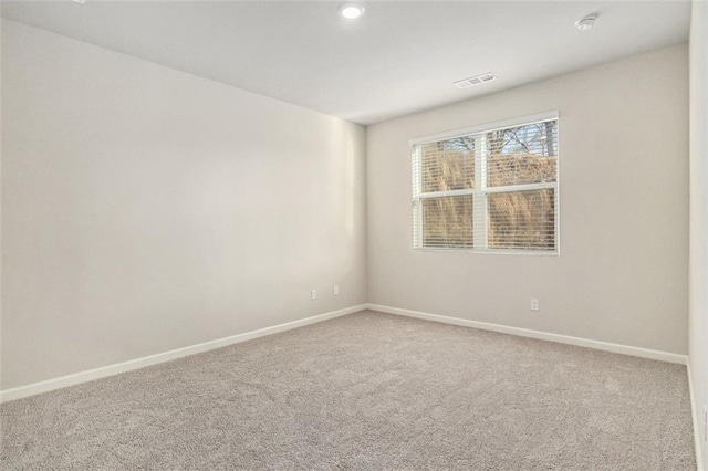 carpeted empty room featuring baseboards and visible vents