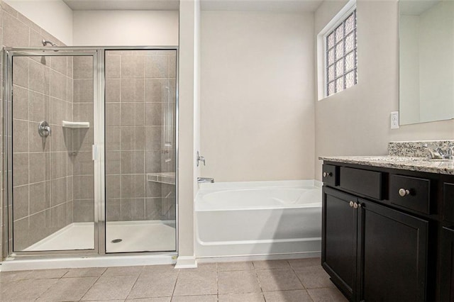 bathroom featuring vanity, a bath, a shower stall, and tile patterned flooring