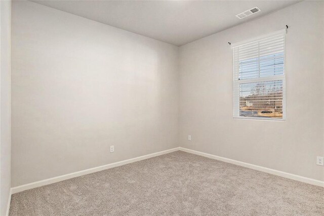 unfurnished room with baseboards, visible vents, and carpet floors