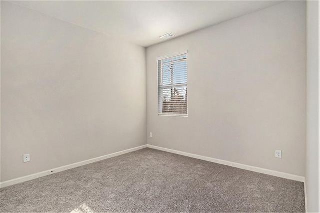 unfurnished room with visible vents, baseboards, and carpet floors