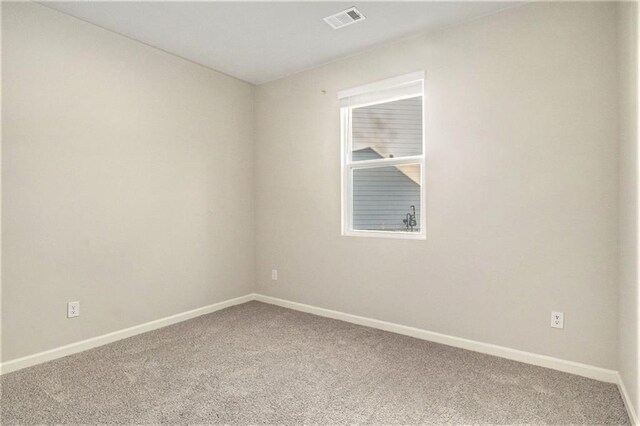 carpeted spare room with baseboards and visible vents