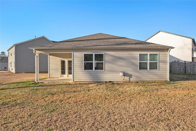 rear view of house with a patio, fence, and a lawn