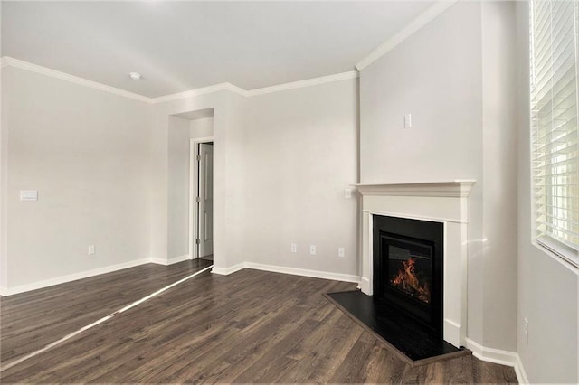 unfurnished living room featuring a glass covered fireplace, crown molding, dark wood-type flooring, and baseboards