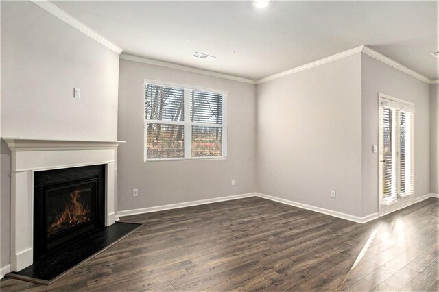 unfurnished living room with baseboards, visible vents, dark wood finished floors, a warm lit fireplace, and ornamental molding