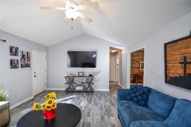 living room featuring lofted ceiling, wood finished floors, ceiling fan, and baseboards