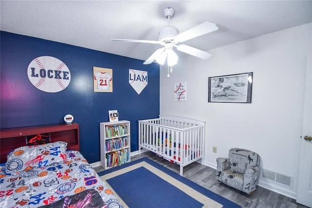 bedroom with wood finished floors, baseboards, and ceiling fan