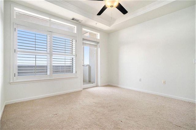 empty room with ceiling fan, ornamental molding, carpet floors, and a tray ceiling