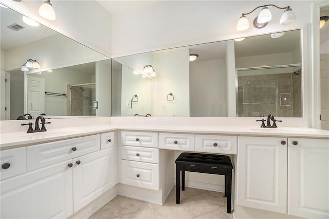 bathroom featuring tile patterned floors, vanity, and a shower with door