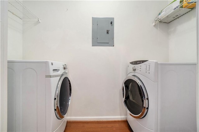 laundry room with hardwood / wood-style floors, independent washer and dryer, and electric panel