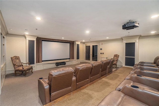 carpeted home theater room featuring french doors and ornamental molding