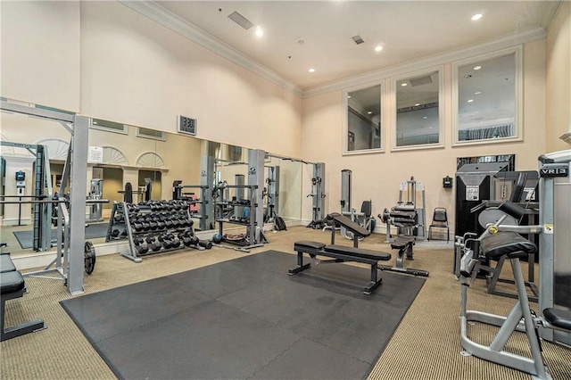 gym with ornamental molding and a high ceiling