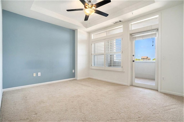 empty room featuring carpet flooring, ceiling fan, a raised ceiling, and ornamental molding