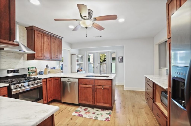 kitchen featuring sink, light hardwood / wood-style flooring, backsplash, stainless steel appliances, and kitchen peninsula