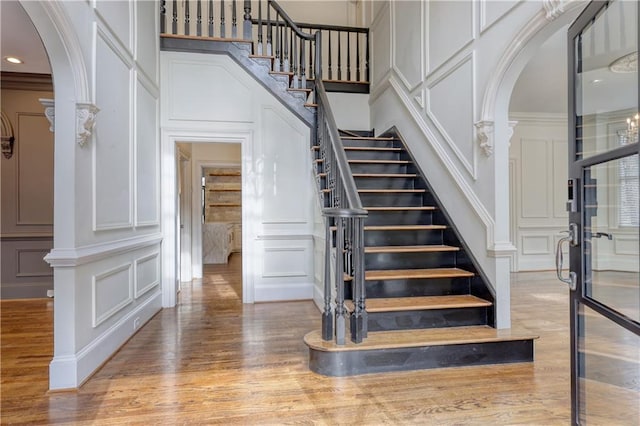 stairway featuring arched walkways and a decorative wall