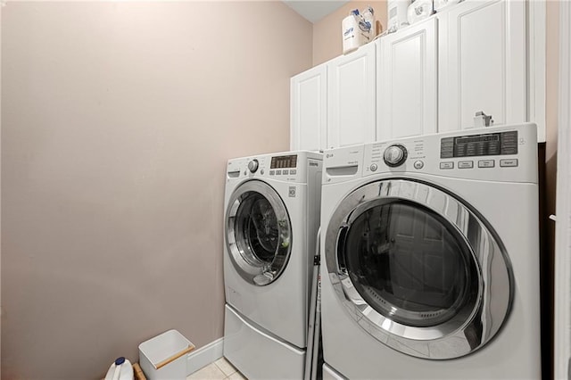 laundry room with cabinets, independent washer and dryer, and light tile patterned floors