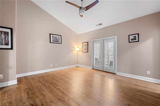 empty room with hardwood / wood-style flooring, ceiling fan, and high vaulted ceiling