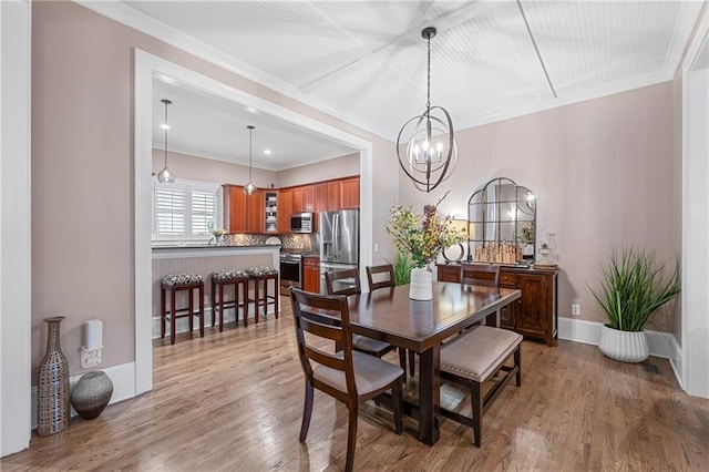 dining space featuring hardwood / wood-style floors, an inviting chandelier, and ornamental molding