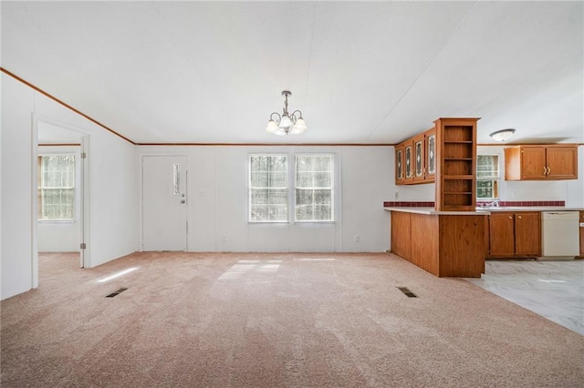 kitchen with brown cabinets, light countertops, hanging light fixtures, glass insert cabinets, and dishwasher