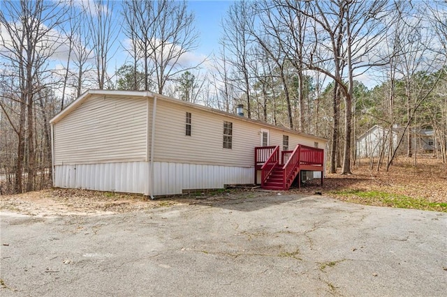 view of home's exterior featuring stairs and a wooden deck