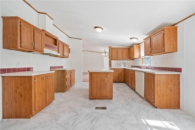 kitchen with brown cabinetry, a center island, light countertops, and dishwasher