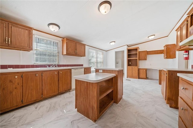 kitchen with brown cabinetry, light countertops, dishwasher, and a center island