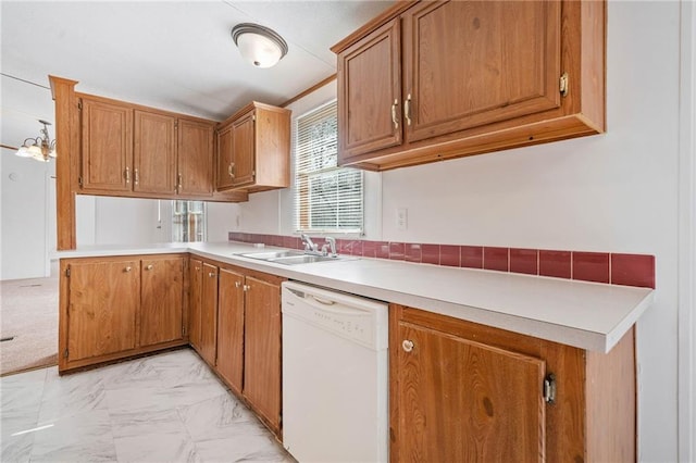 kitchen featuring brown cabinetry, marble finish floor, white dishwasher, light countertops, and a sink