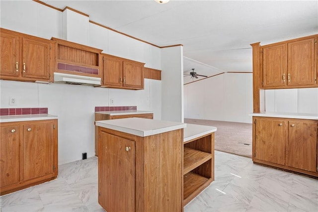 kitchen featuring brown cabinetry, light countertops, and open shelves