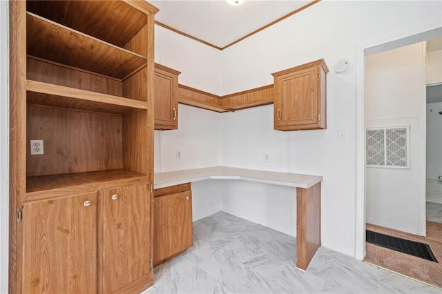 office space with marble finish floor, built in desk, and visible vents