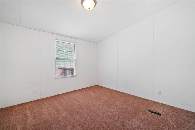 carpeted empty room featuring visible vents