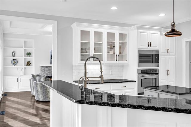 kitchen featuring white cabinets, glass insert cabinets, dark stone countertops, dark wood-type flooring, and stainless steel appliances