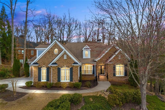 view of front of home featuring concrete driveway and brick siding