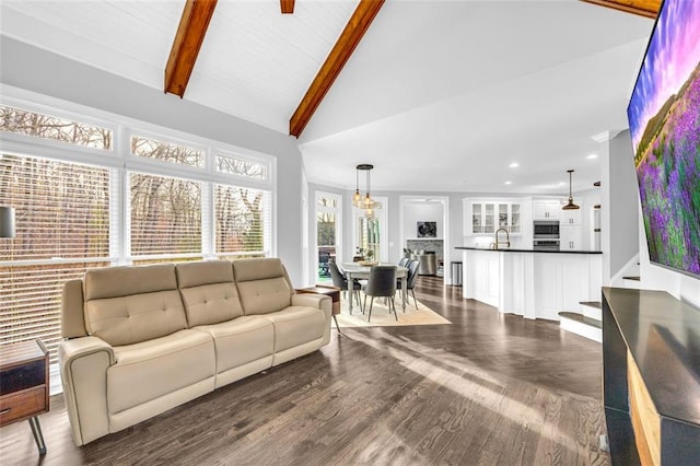 living area with stairway, dark wood-type flooring, beamed ceiling, high vaulted ceiling, and recessed lighting