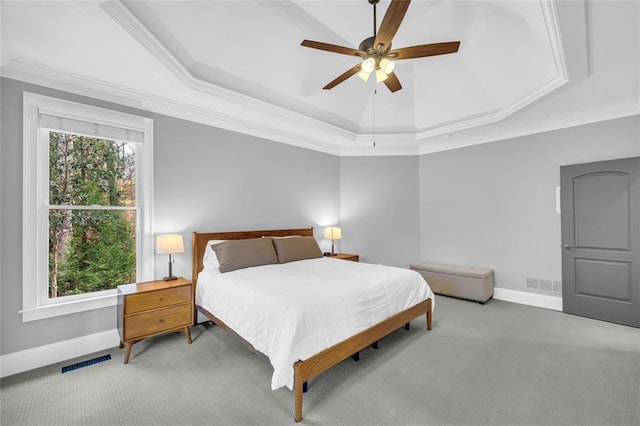 bedroom with carpet floors, a tray ceiling, visible vents, and ornamental molding