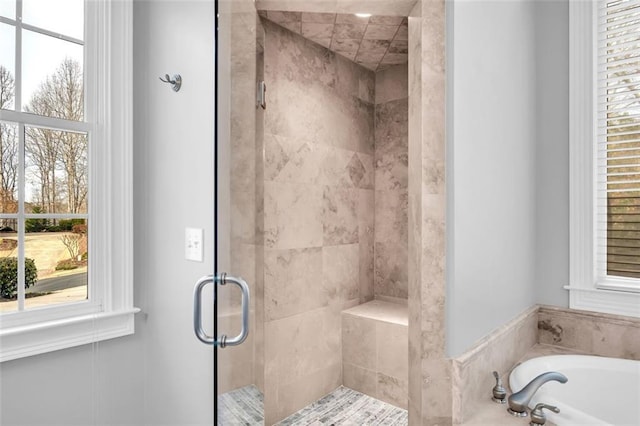 bathroom featuring a garden tub and a shower stall