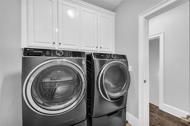 laundry room with cabinet space, baseboards, wood finished floors, and independent washer and dryer