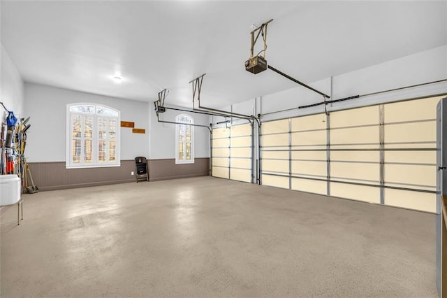 garage featuring a garage door opener and a wainscoted wall