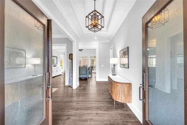 foyer with ornamental molding, dark wood finished floors, and baseboards