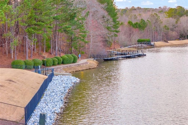 view of water feature with a boat dock and fence