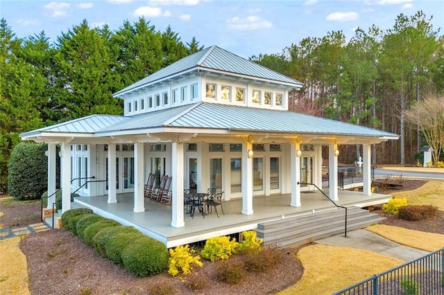 back of house featuring a standing seam roof, metal roof, and covered porch