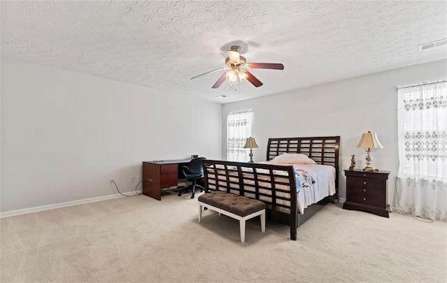 carpeted bedroom with a textured ceiling and ceiling fan