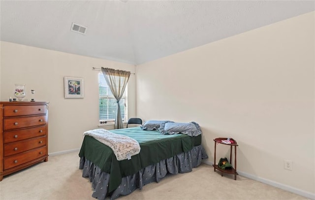 bedroom with light colored carpet and lofted ceiling