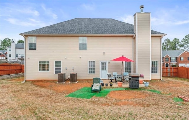 back of house featuring a yard, central AC unit, and a patio area