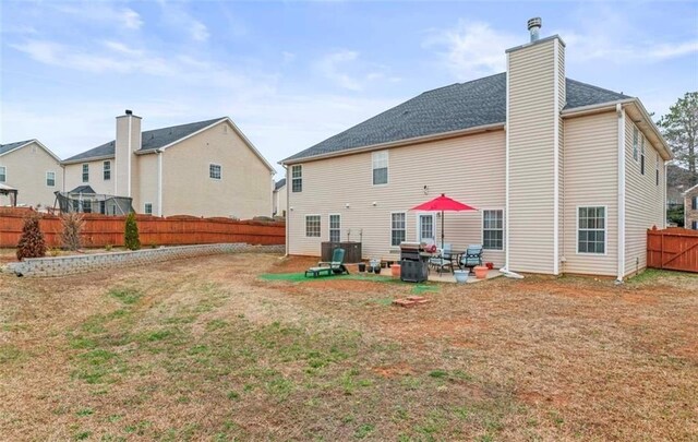 back of property with a yard and a patio