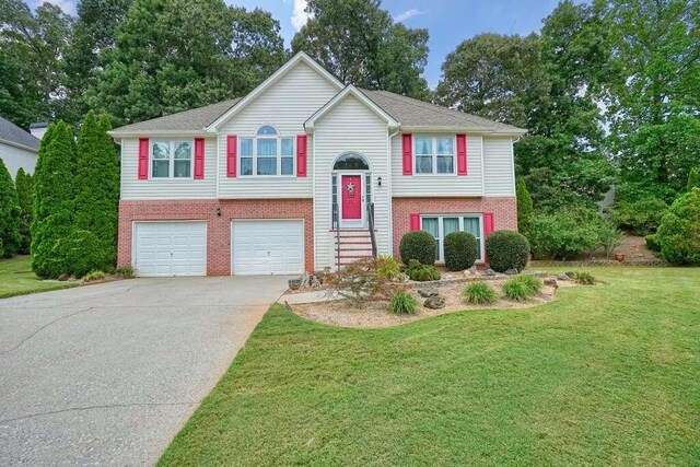 split foyer home featuring a garage and a front lawn