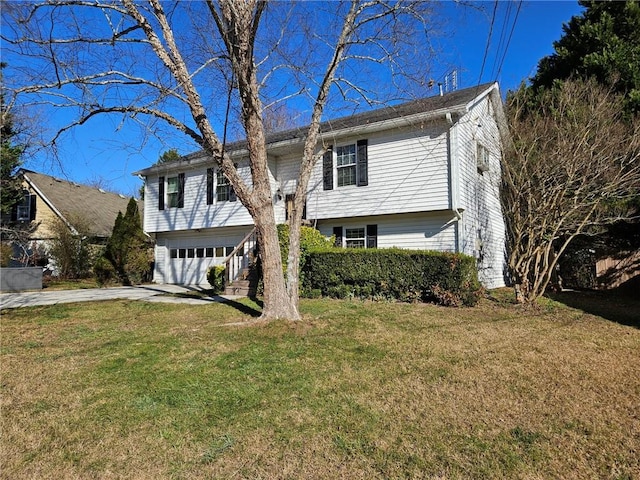 split foyer home featuring a garage and a front yard