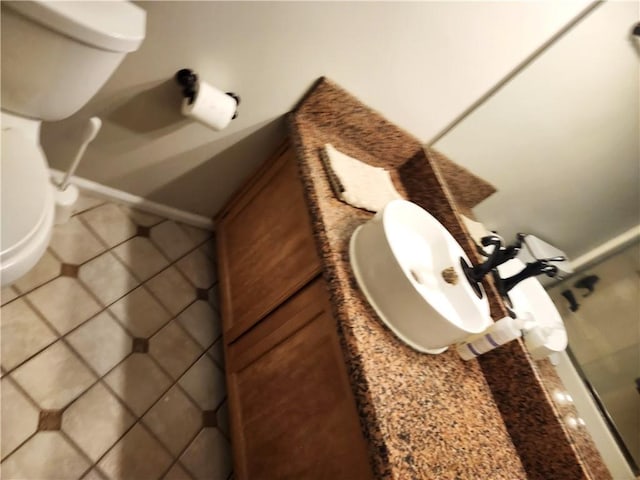 bathroom with tile patterned flooring, vanity, and toilet