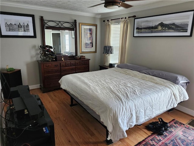 bedroom featuring ceiling fan, crown molding, wood-type flooring, and a textured ceiling